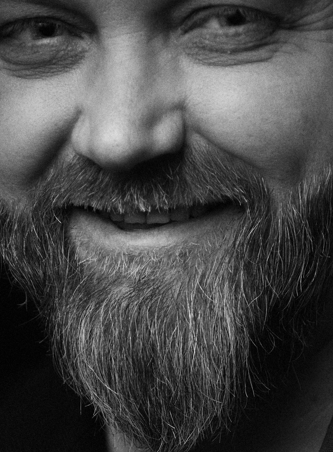 Studio portrait of a man with beard smiling